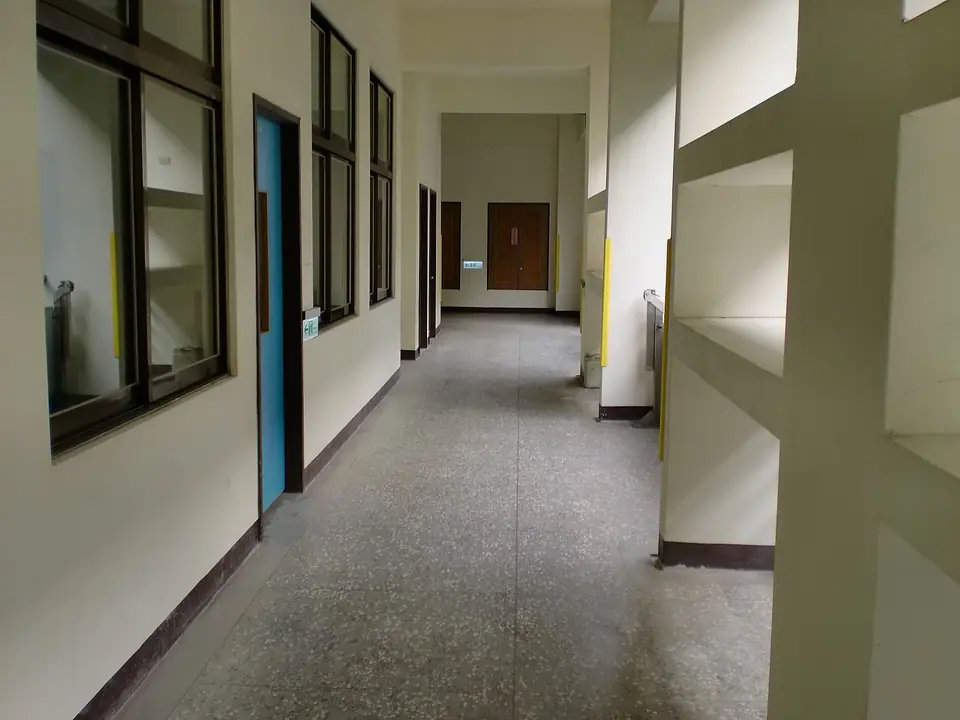 Ders saatinde boş kalmış, iki yanında sınıf kapıları olan uzun bir okul koridoru
