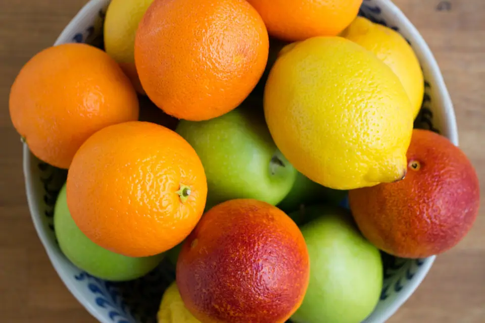 Seramik kâsede portakal, kan portakalı, limon ve yeşil elmalar